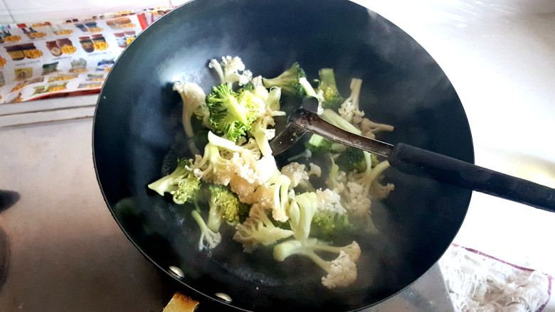 咖喱时蔬,锅中放水,煮沸后,放入有机花菜和西蓝花,汆水,放一小勺盐。