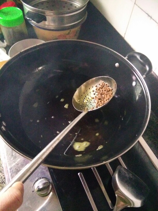 《老爸的厨房》之年味酥肉,当干花椒的味儿融入油中后,将干花椒残渣用漏勺捞出,一定要捞干净,否则花椒炸糊了粘在酥肉上会有苦味儿,影响口感