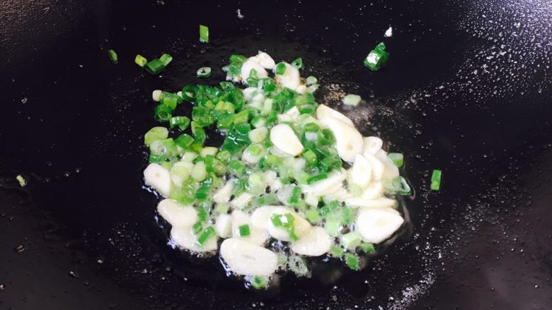 豌豆烧茄子饭,锅里留少许底油,放入蒜片和葱花爆香。