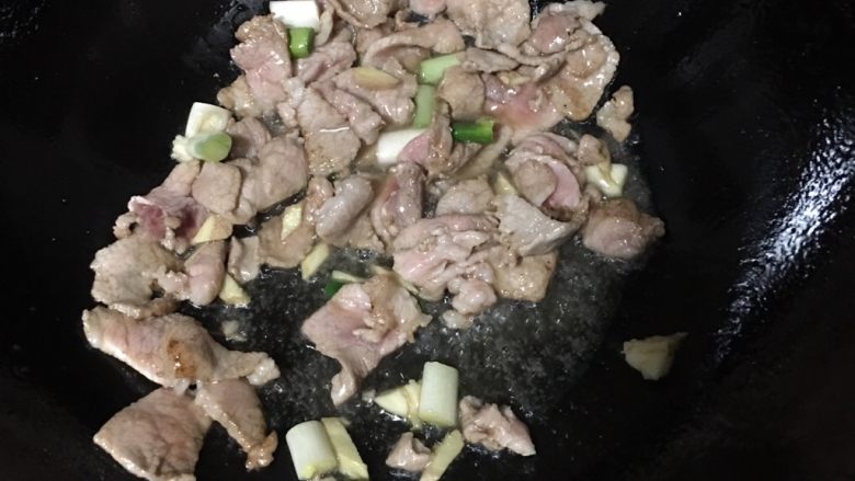 芹菜炒猪肉,倒入猪肉，锅内翻炒一会加葱姜蒜