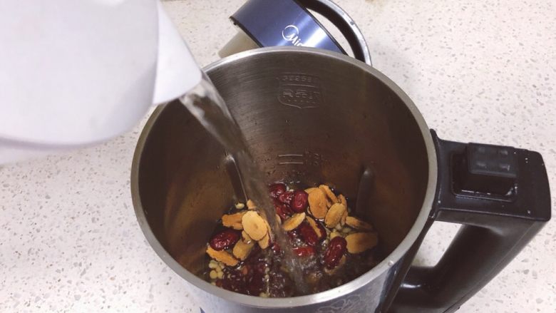 红枣红豆豆浆,然后把浸泡的豆子倒入豆浆机里,倒入红枣,倒入过滤的清水,直到水到水位线之间。