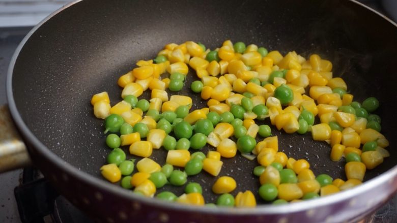 海鲜炒饭,用另外一个锅加入油,倒入玉米粒和豌豆