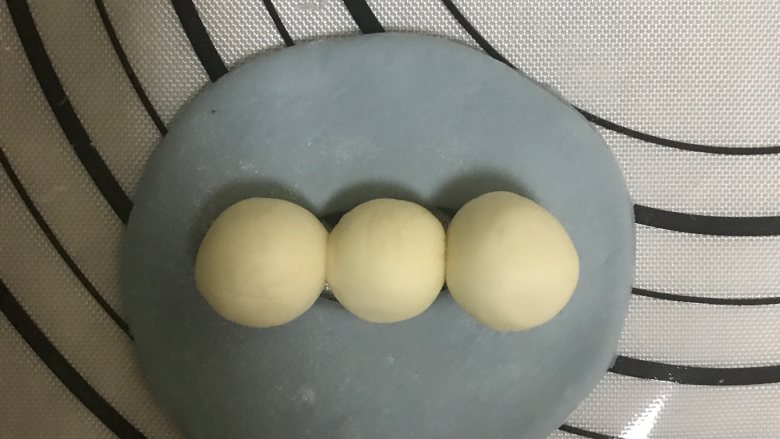 花式面点—豌豆荚馒头,取三小块白色面团,搓成光滑的圆球,摆在中心