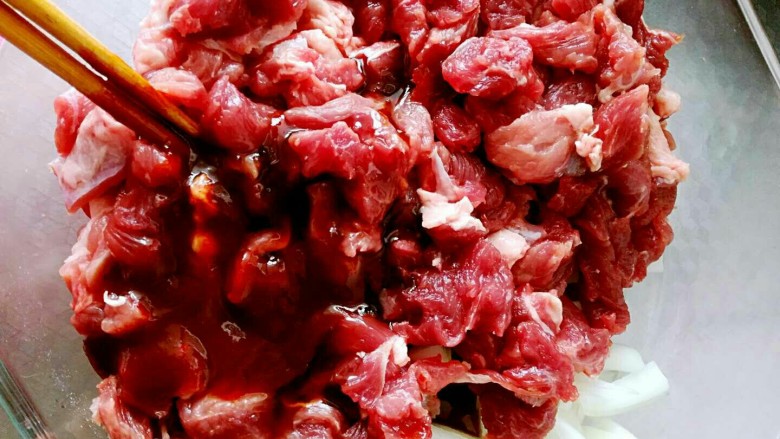 酱香牙签肉,切好的牛肉块和圆葱放在一起,圆葱可以提香,去腥味。再倒入一袋左右腌肉料(预留一汤匙左右的料)