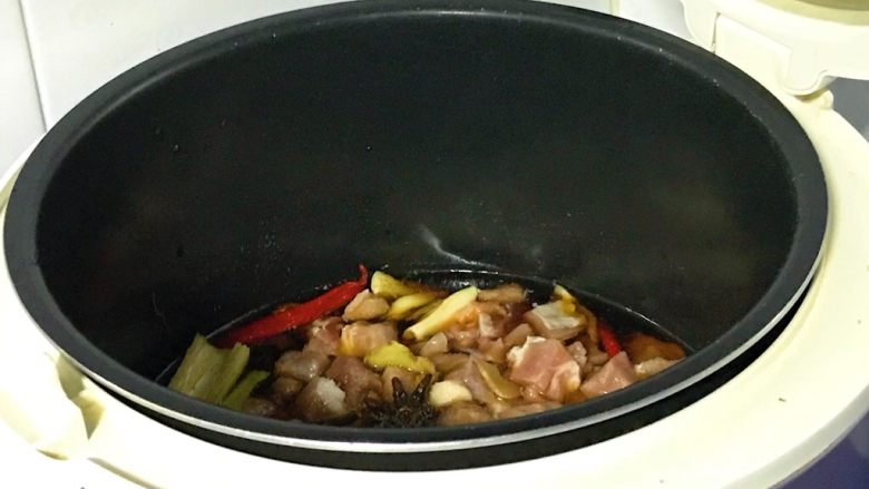 电饭煲+梅菜烧肉,搅拌一下,准备开电,盖上盖子,启动煮饭模式。锅里的水量足够煮烂猪肉的。等待自动跳闸,焖十分钟。