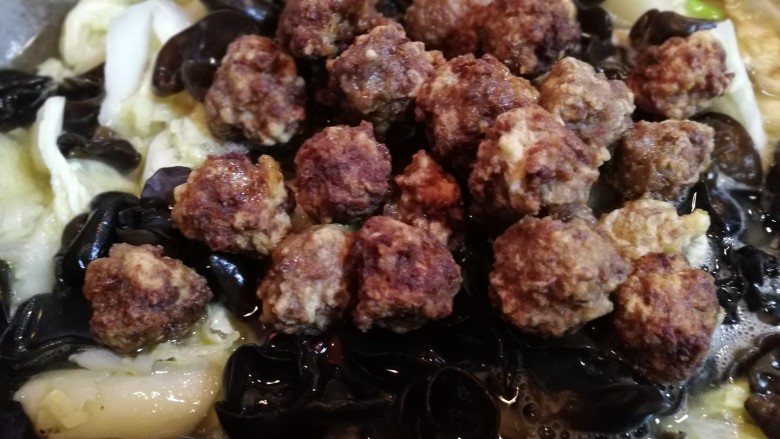翡翠白菜黑缎木耳牛肉丸,将炸好的牛肉丸放在木耳上面。炖10分钟左右。