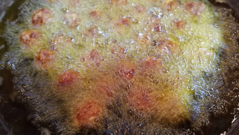 翡翠白菜黑缎木耳牛肉丸,肉馅团成一个个小圆下入锅内。炸熟
