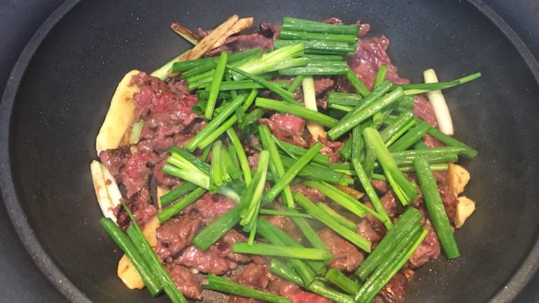 炒牛肉,将牛肉用煎的方式翻过来，再撒上葱段，等它颜色不在鲜红看不到血水，这是可以翻两三下，然后上盘