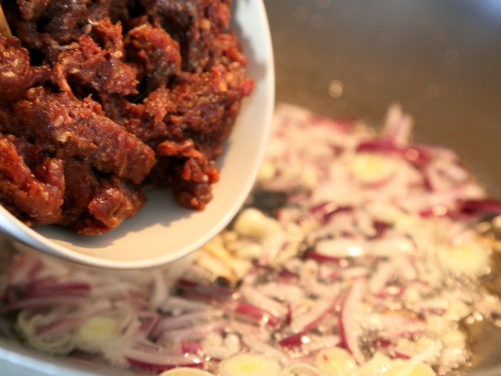 牛肉番茄酱意面,热锅热油先下洋葱、葱白和大蒜翻炒出香味,再下肉末炒。