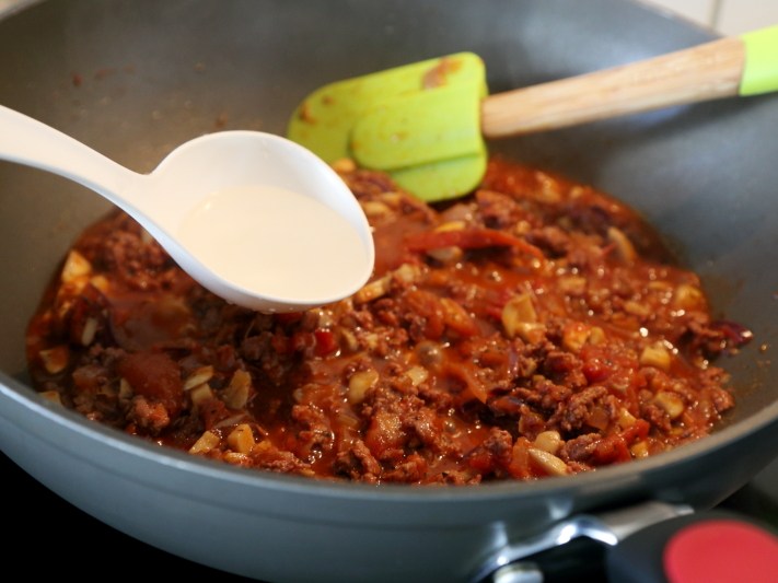 牛肉番茄酱意面,然后倒入少量的水,盖上锅盖焖煮5分钟左右,让酱汁更加浓郁。