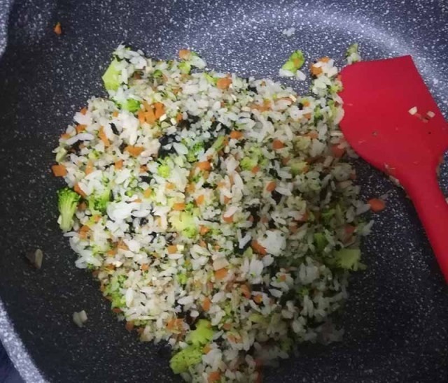 什锦饭团,倒入大米饭翻炒,直至米饭成了一粒一粒的状态。