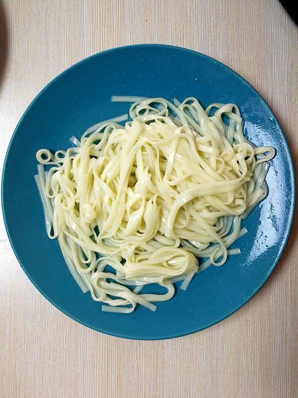 特色干拌面,捞出煮好的面条,水龙头过凉水,沥干水分;