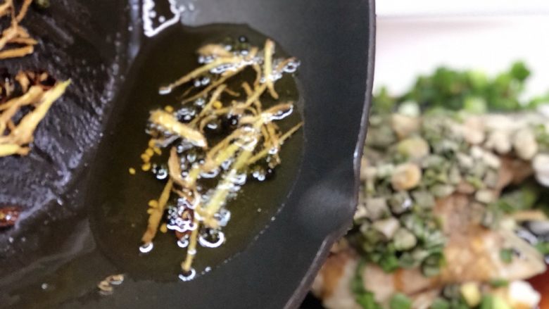 椒香葱油鲈鱼,淋上热油,煸炒过的姜丝这些可不要丢了,一起放入