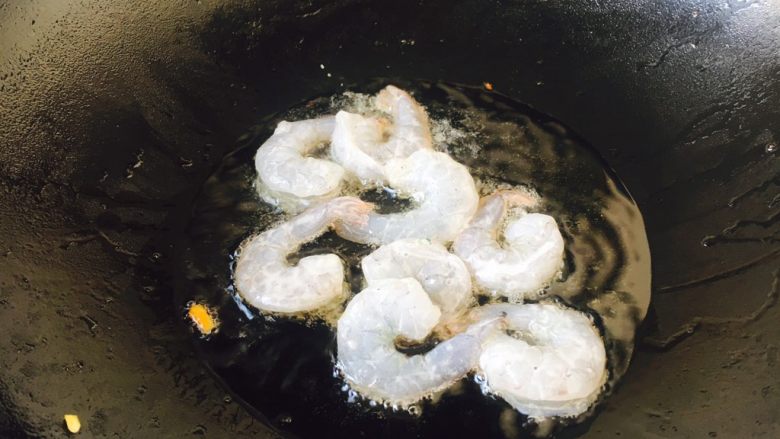 美味早餐 鲜虾什锦炒饭,炉灶上置不粘锅,待锅微热时放入约30g的炒菜油,待油5~6成热的时候放入腌制好的虾仁。