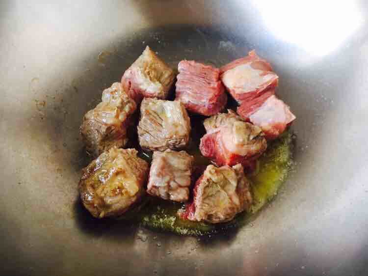 咖喱牛肉胡萝卜土豆饭,放入牛腩块,中火煎制。