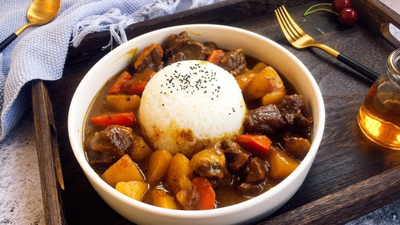 咖喱牛肉胡萝卜土豆饭,将咖喱牛肉胡萝卜土豆放在盘子的周边即可。