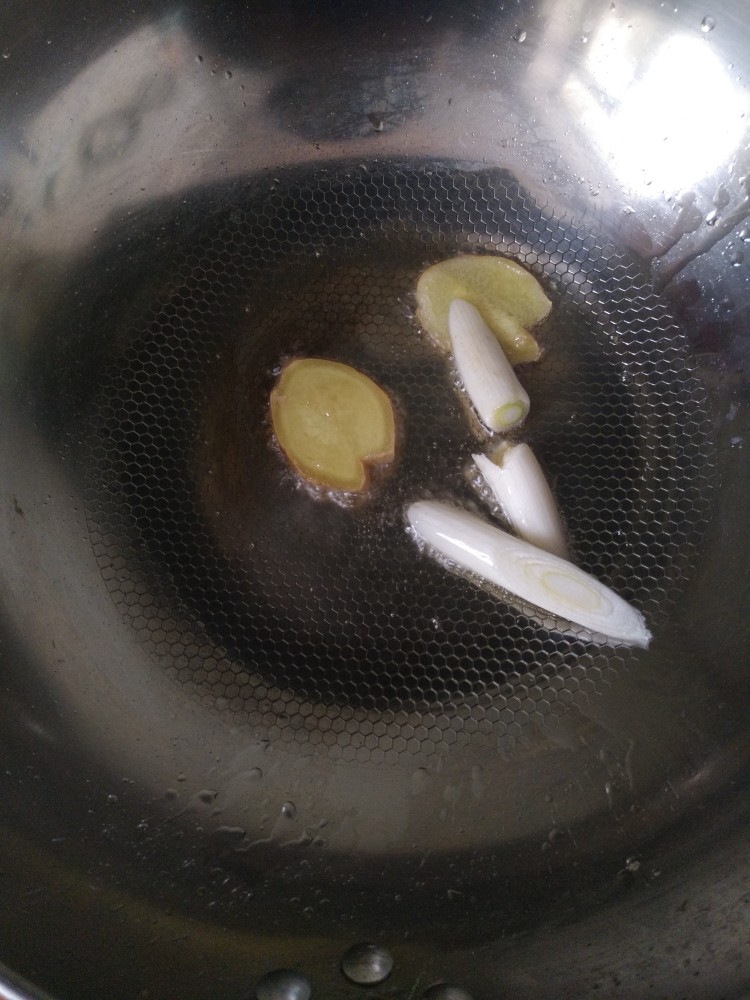电饭煲-酱焖排骨,锅中放油,下葱姜爆香。也可以加点花椒粒炝锅。
