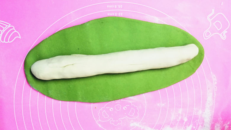 零失败家常翡翠白菜饺,此时的面团醒好了,面色面团搓成长条,青色面团擀开,能完全包住白色面团为止,尽量包紧些。