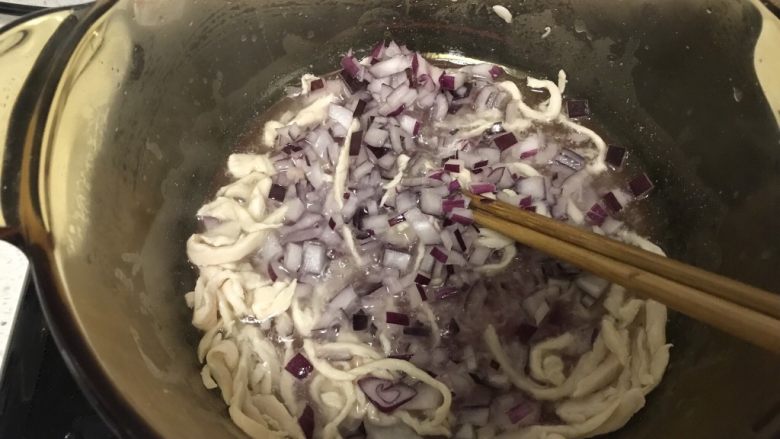 松子鸡肉罗勒意面(附青酱做法),待鸡肉炒变色后加入洋葱翻炒。