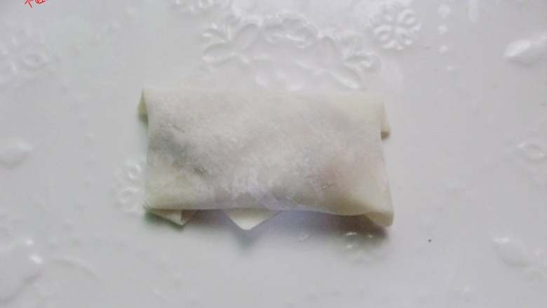 猪肉春卷,往上卷起来, 两边往中间折起来,继续卷,在三角上抹鸡蛋液, 封口粘好
