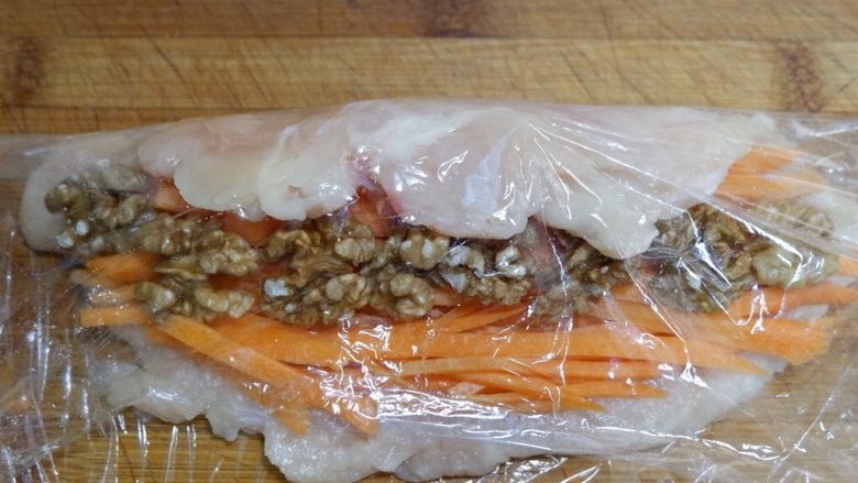胡萝卜核桃鸡肉卷,翻过来,利用保鲜膜卷起来