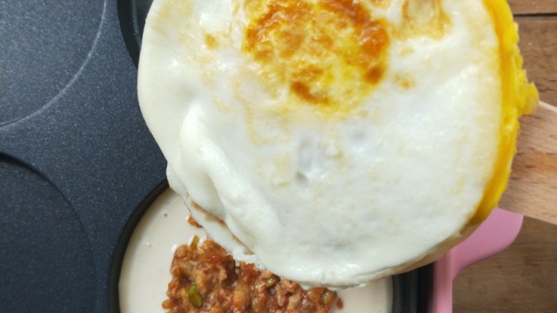 复刻街头美食~网厨第一个肉蛋堡,把步骤14的蛋饼取出翻面扣在这个新面糊肉馅上。
~也就是鸡蛋这一面朝着刚刚做的面糊肉馅。