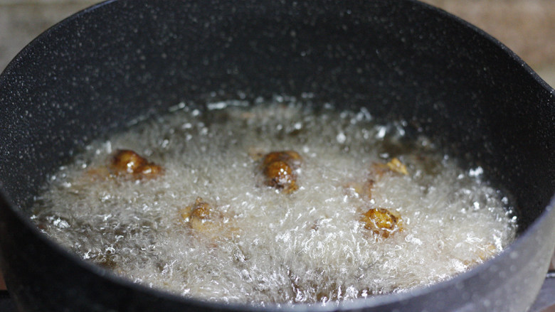 辣！辣！辣掉眉毛的干椒辣子鸡,鸡肉腌好后，取雪平锅倒油，油要多倒一点。大火加热至沸腾后放入鸡块炸至表皮变酥，捞出后控油备用。