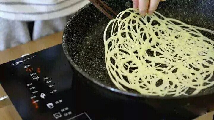网格蛋卷,待面糊完全凝固后,可以整个掀起翻面再煎一下。