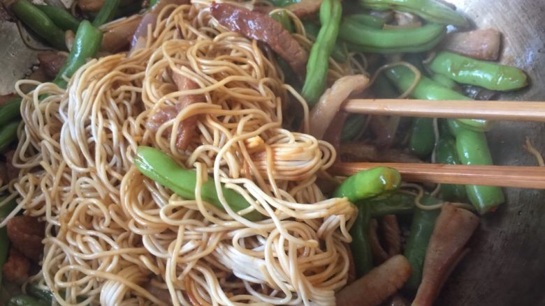 豆角焖面,用筷子快速翻拌面条，裹匀汤汁即可。