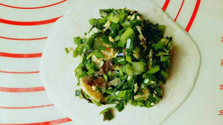 #家的味道#-东北特色~韭菜盒子,取一小块面团用擀面杖擀圆饼,包上韭菜鸡蛋馅。