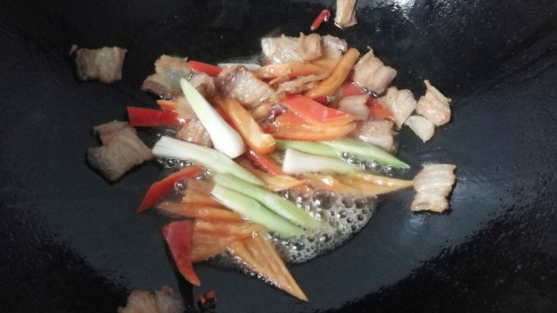 腊肉干锅鸡腿菇,再下入蒜白翻炒几下;