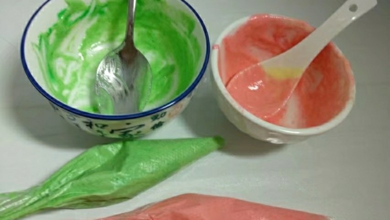 手绘樱桃南瓜豆浆蛋糕卷,两个小碗各打入两勺蛋糕糊,加入色素搅匀,装入裱花袋。(用一勺蛋糕糊加一滴色素也够)