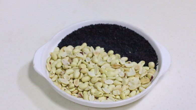 花生芝麻牛轧糖,把烤好的花生去皮,和黑芝麻一起放在盘子内备用。