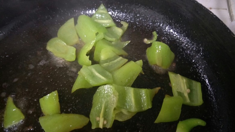 西红柿炒鸡蛋,锅中放油,加入青辣椒炒。