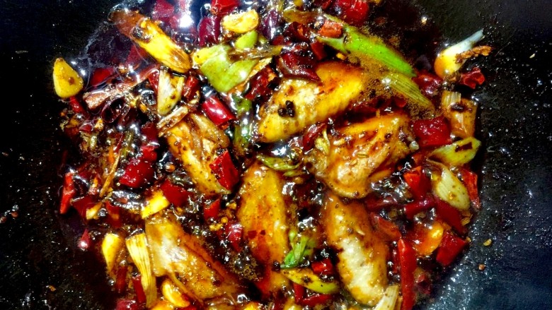 秘制麻辣香锅,倒入香锅料小火炒香后,放入翅中,小火熬制几分钟入味