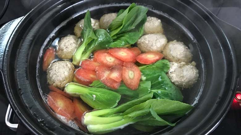 荸荠肉丸汤,放入青菜和胡萝卜。再次煮开即可出锅。