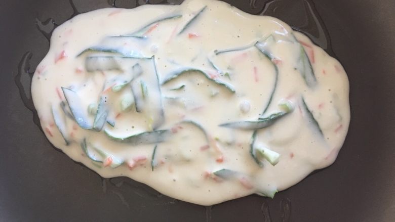 快手早餐 海苔蛋饼卷,热锅倒油,将面糊倒入锅中,摊成一个椭圆形的饼