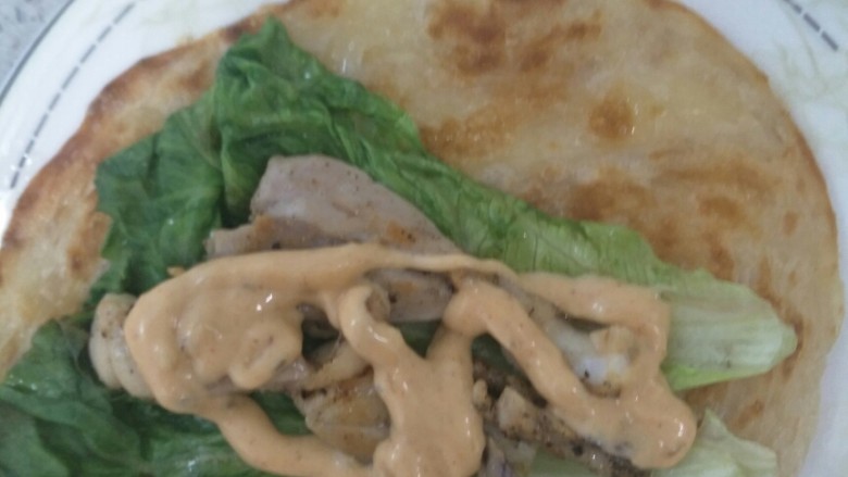鸡腿手抓饼,开始组装了,饼上放入生菜再放入鸡腿放入千岛酱。可以放入你喜欢的酱。