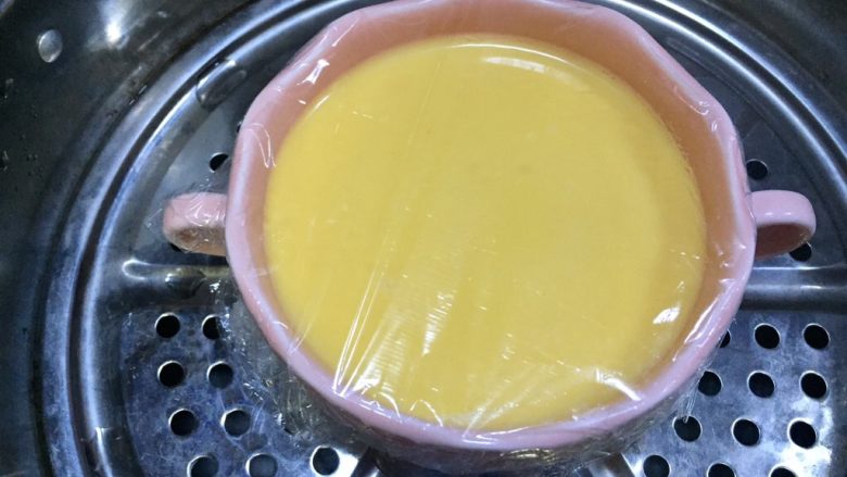 牛奶虾仁蒸蛋,蒙上保鲜膜,放入蒸锅里开蒸