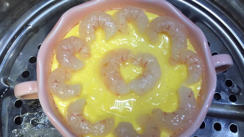 牛奶虾仁蒸蛋,取下保鲜膜按自己喜欢的造型放上虾仁,再蒙上保鲜膜继续蒸五分钟左右就好了