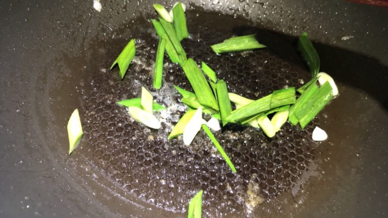 赛螃蟹,锅中油倒出,留少许底油,放入大蒜段煸炒。