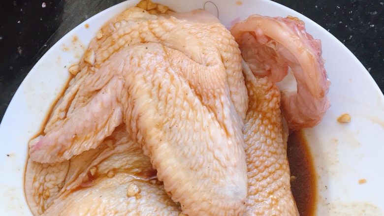 电饭煲焗鸡,翻到正面,照样勺一勺酱汁在鸡身上,涂匀用手轻轻按摩一下,然后静置片刻