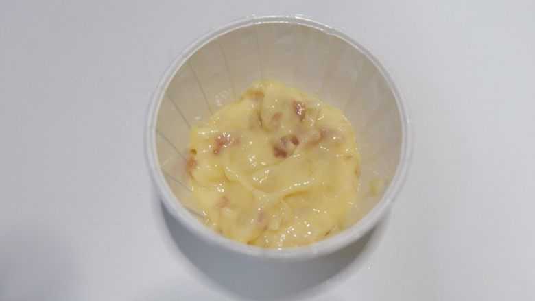 抱蛋培根咸麦芬蛋糕,用小勺取适量面糊,铺在纸杯底部