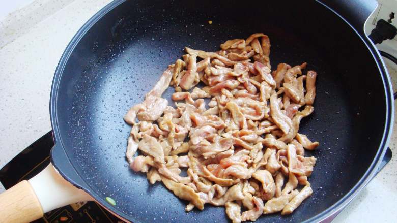 青椒炒肉片,倒炒锅里倒入适量食用油,油热后倒入腌制好的肉片翻炒变色。