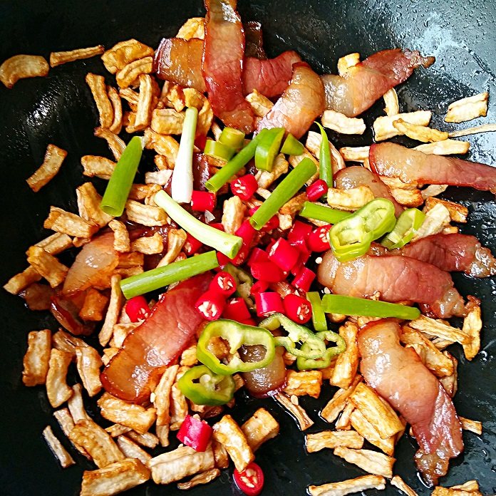 湘味萝卜干炒腊肉,然后加入杭椒,小米辣和小葱段,大火翻炒断生。