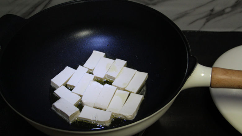 鸡蛋煎豆腐,油锅烧热,最好用不粘锅,这道菜就非常容易操作,铁锅容易粘锅,因为这豆腐太嫩了。
