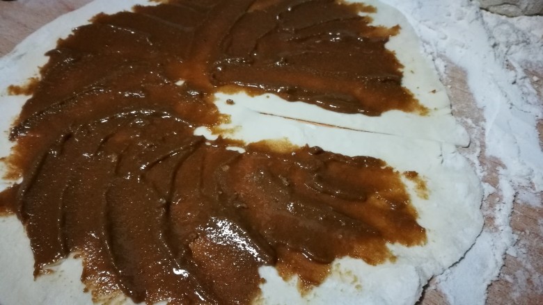 香甜诱人~芝麻酱糖饼,从中心向一边边缘切一刀 将搅拌好的酱涂抹在面皮上