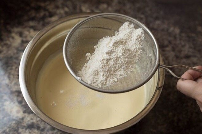 草莓奶油瑞士蛋糕卷,将面粉分次筛入蛋黄糊中,搅拌均匀至无颗粒状态,放置一边备用。