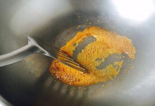 天津甘栗焖鸡,这是滑动铲子后消泡的状态 当再产生气泡时,还是用铲子滑动,打散气泡,这样重复3次,糖色就变成琥珀色了。