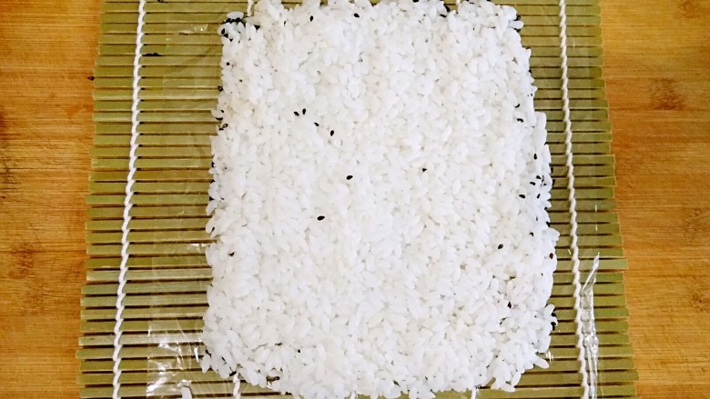 肉松油条饭团――秒杀K家同款握的大饭团,将米饭铺在上面,用手(戴好厨房一次性手套)压至薄厚均匀。